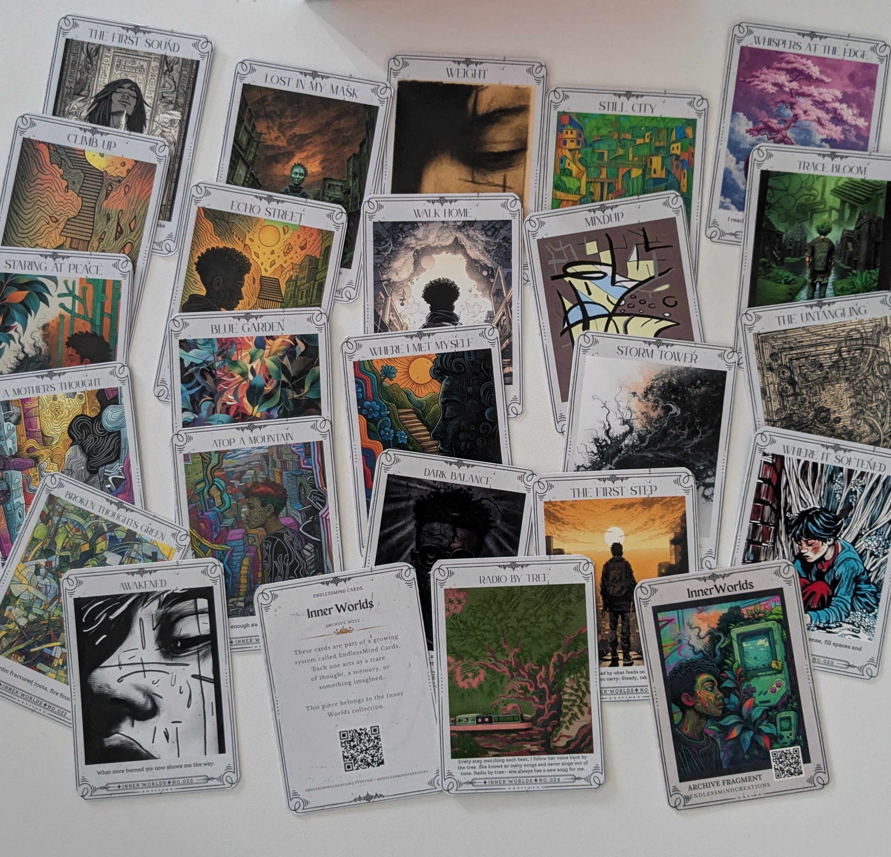 Collection of colorful art cards on a white surface with a box in the background.